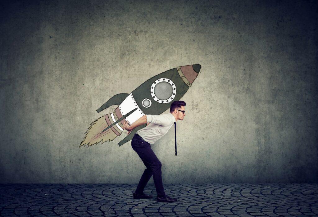 Mann mit gezeichneter Rakete auf dem Rücken symbolisiert Startup-Wachstum | Lohnabrechnung Outsourcing